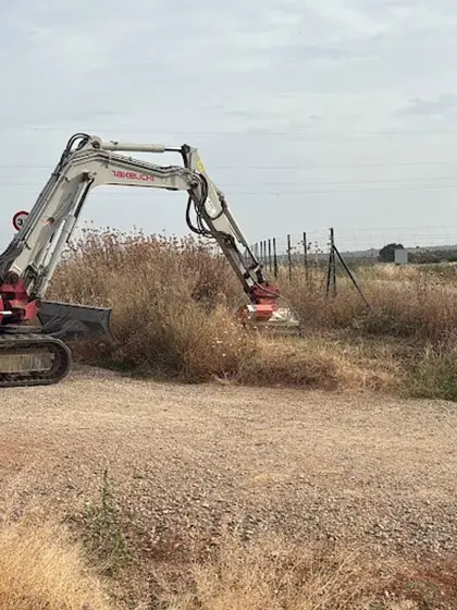 Desbroce mecánico de márgenes de carretera con retroexcavadora equipada con implemento rotativo Trabajo realizado conforme a buenas.