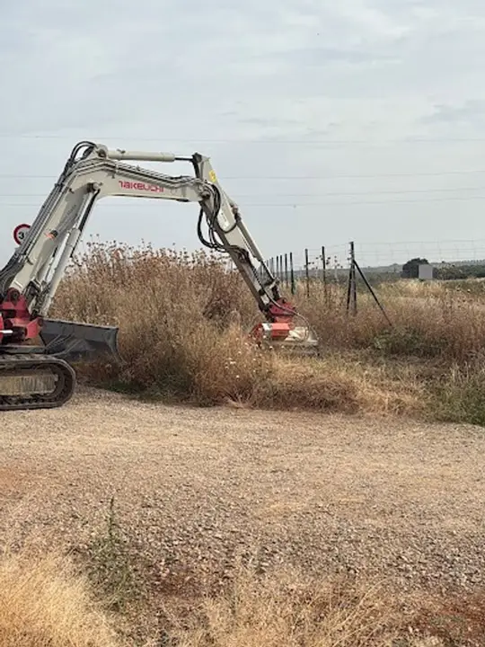 Desbroce mecánico de márgenes de carretera con retroexcavadora equipada con implemento rotativo Trabajo realizado conforme a buenas.